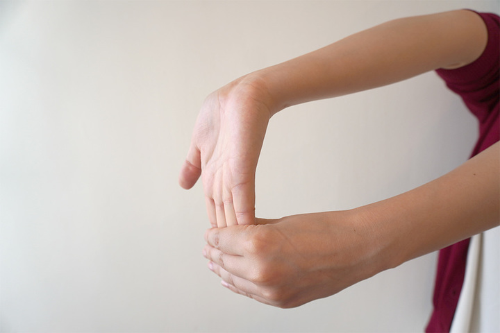 ▲指を曲げる筋肉のストレッチ。片方の手のひらを上に向け、反対の手で指を反らせる