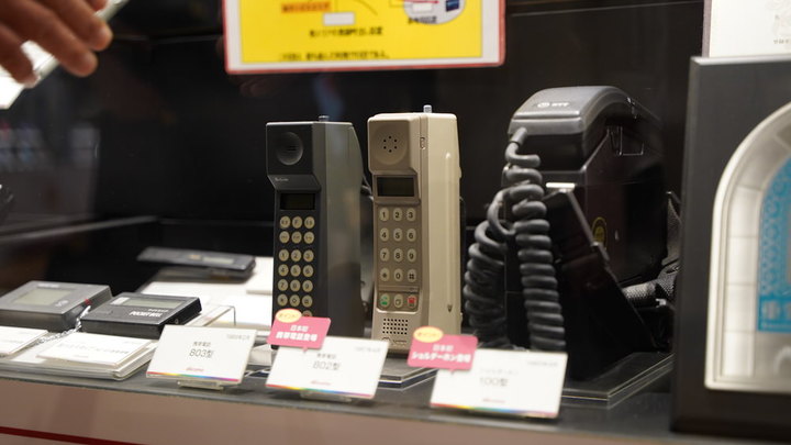 真ん中のグレーの電話が、日本初の携帯電話「TZ-802型」（1987年発売）